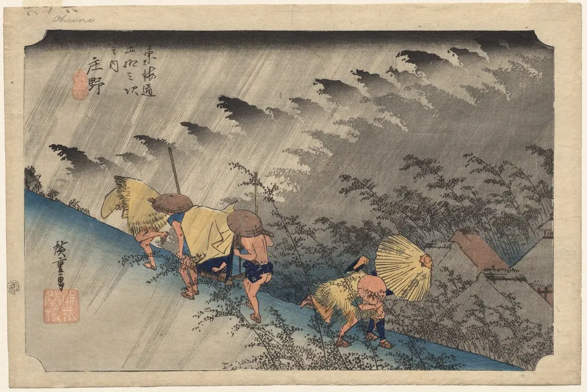 Masterpiece woodblock print of travelers hurrying in opposite directions up and down a hillside path during a fierce rainstorm