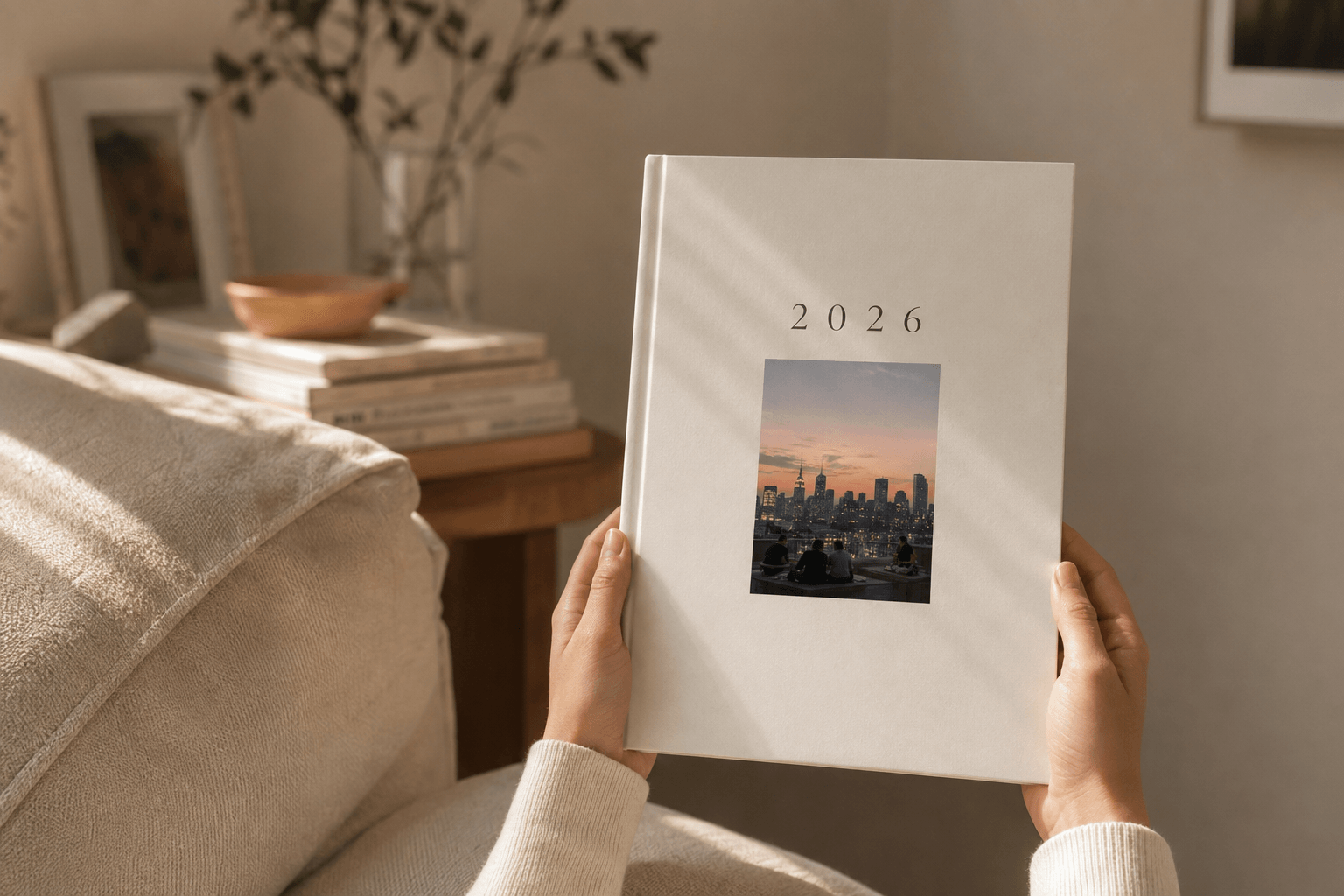 Closed yeerbook cover with a rooftop skyline photo inset, held in two hands